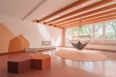 Gruppenraum mit Traumschwinger in der Kita Kindergartenmöbel und Raumgestaltung: Von Papoq gestalteter Gruppenraum mit Traumschwinger von Mira-Art und Spielpodest, schafft eine warme und gemütliche Atmosphäre im Kindergarten.