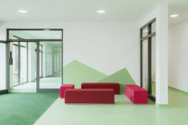 Eingangsbereich in der Kita mit Sitzmöbeln Eingangsbereich einer Kita mit gemütlichen Sitzmöglichkeiten für Eltern, geplant von Papoq für Ankommen und Wohlfühlen.