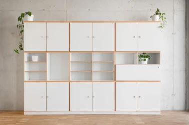 Möbelbaukasten Kindergarten und Schule Kindergartenmöbel und Raumgestaltung: Schrankwand bestehend aus verschiedenen Modulen unseres Möbelsystems, einschließlich offenen Fächern, Türen und Sekretärschrank, in hellem, modernem Design mit Buchekante.