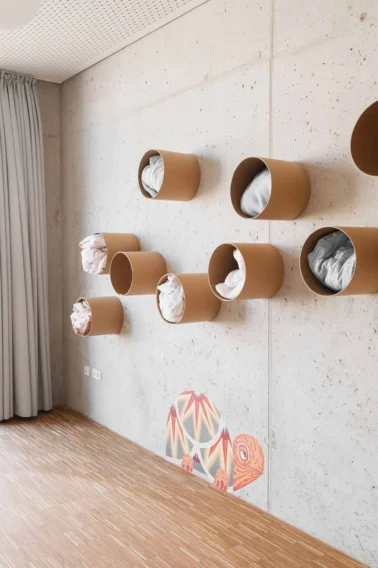 Röhrenregal für Bettwäsche im Schlafraum Kindergartenmöbel und Raumgestaltung von papoq: Aufbewahrung der Bettwäsche im Schlafraum in Röhrenregalen, die die Eigenständigkeit der Kinder fördern und Ordnung schaffen.