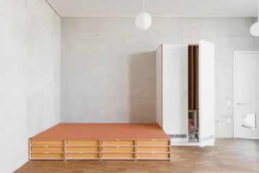 Kita Schlafraum mit Matratzenpodest und Matratzenschrank Kindergartenmöbel und Raumgestaltung: Matratzenpodest und Matratzenschrank im Schlafraum der Kita, mit einem Tretford-Teppich auf dem Podest für zusätzlichen Komfort und Gemütlichkeit.