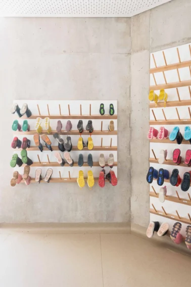 Gummistiefelpaneel in der Garderobe Kindergartenmöbel und Raumgestaltung: Gummistiefelpaneel an der Wand, das zahlreiche Matschschuhe ordentlich verstaut und ein effektives Trocknen der Gummistiefel ermöglicht.